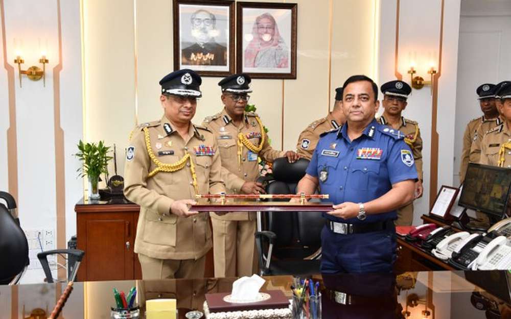 Chowdhury Abdullah Al-Mamun(left) Bangladesh’s new Inspector General of Police, receives the ceremonial baton from predecessor Benazir Ahmed at police headquarters in Dhaka, Sept. 30, 2022.Photo Courtesy Police Headquarters Bangladesh via BenarNews 
