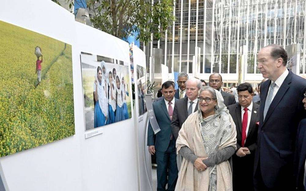 Bangladesh Prime Minister Sheikh Hasina (center left) and World Bank President David Malpass (second from right) look at pictures as they jointly inaugurate a photo exhibition at World Bank headquarters in Washington, May 1, 2023.Photo courtesy Bangladesh Press Information Department Via RFA